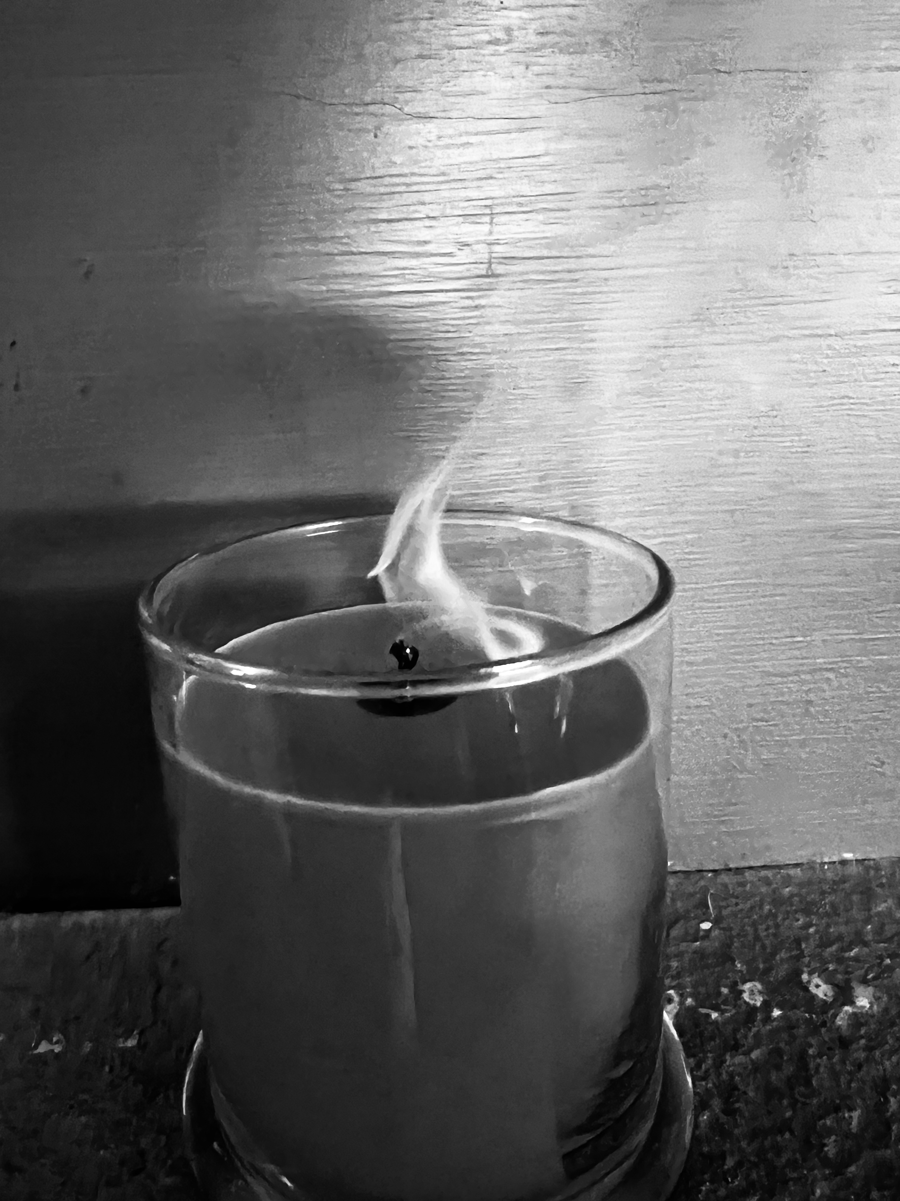 A photo in black and white of a candle with its flame recently extinguished. Photo by Jeri Lynn Organtini.