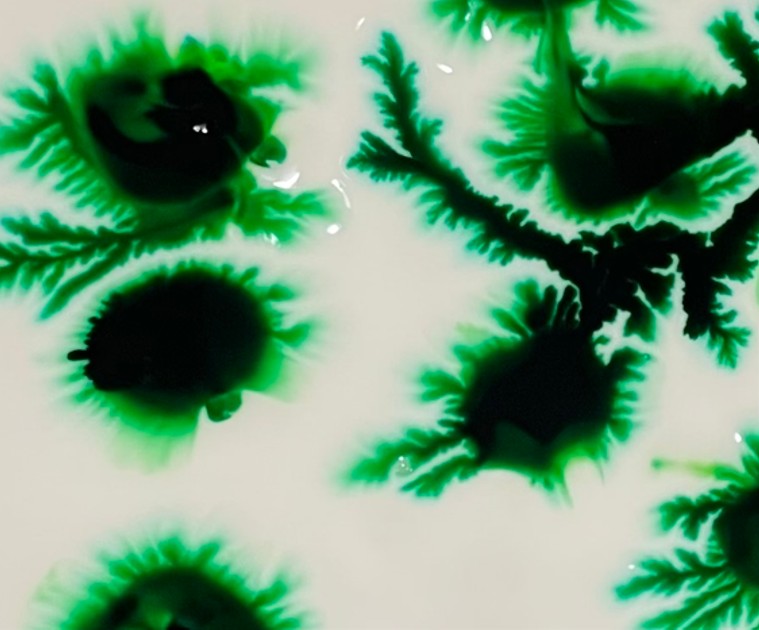 black droplets breaking out into green tentacles